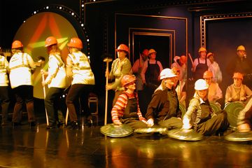 People performing on a stage with recycled materials at the end of team building activity Street Beat.
