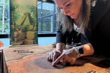 Participant solving a puzzle during the Passport to Adventure indoor team building activity.