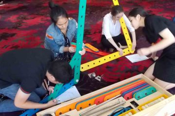 team collaborate to complete rat trap collaborative team building activity