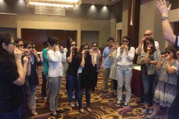 team practising to play the harmonica team building musical activity