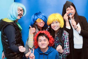 five people wearing wigs and funny accessories unny wig and a big bow tie in the picture fun team building activity