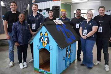 team show off their dog kennel