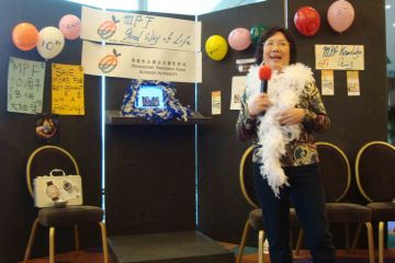 team posing with their arms up out of the box team building activity