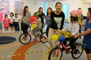 smiling women give newly built bikes to happy children