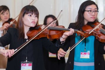 women playing violin crescendo musical team building activity