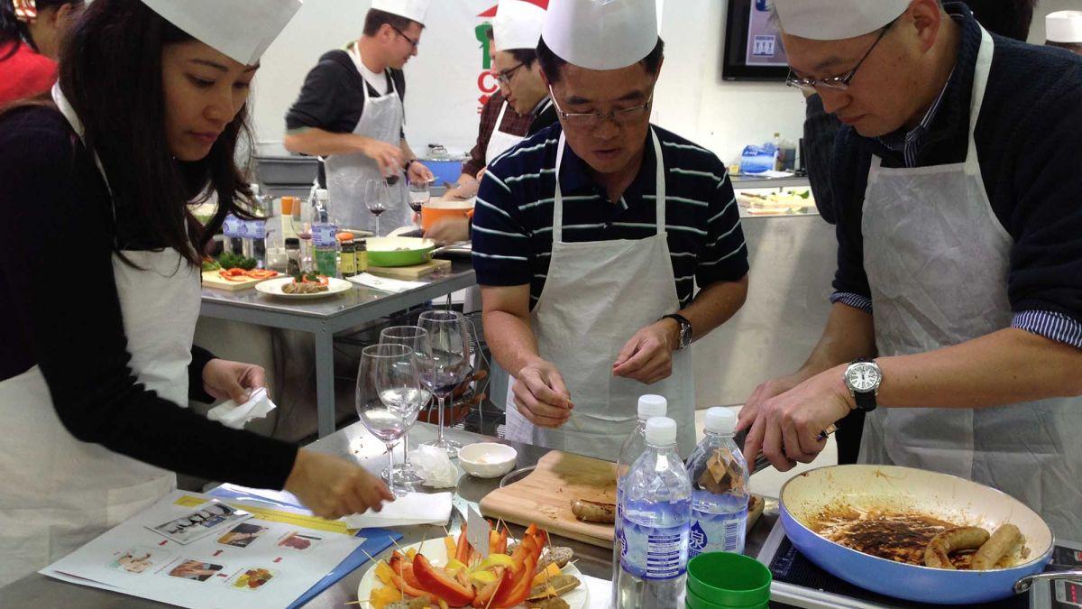 team collaborate to complete cooking team building activity sausage sensation culinary