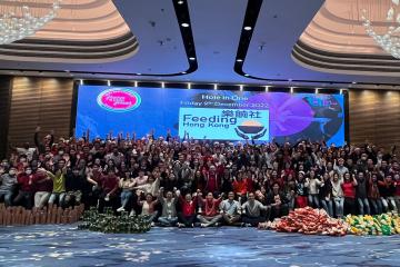 team picture of hole in one with donated food