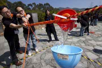 employees collaborate to complete breakthrough team building activity outdoors