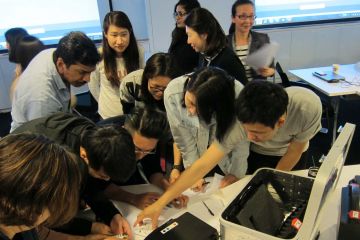 employees collaborating to complete beat the box team building activity