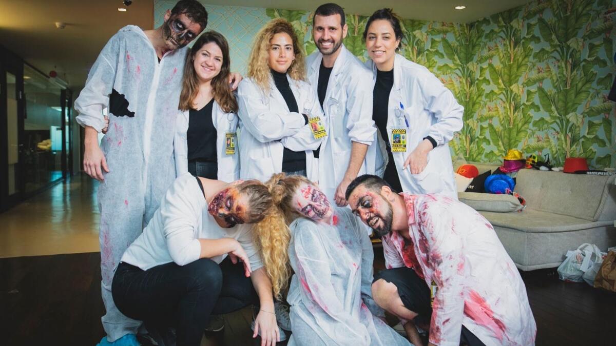 Team participating in Halloween-themed team building activity with costumes, puzzles and collaborative challenges in a fun workplace setting