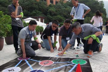 employees collaborate to complete breakthrough team building activity