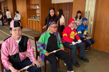 Colleagues engaged in lively racing activity with cheering spectators