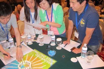 team collaborate to complete essence of excellence team building activity