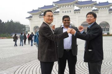 3 men in front of a landmark discovery challenge team building