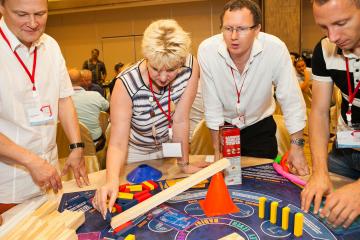 people constructing a rube goldberg machine in catalyst team building activity Chain Reaction