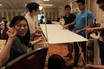 employees collaborate to complete bridging the divide creative team building activity