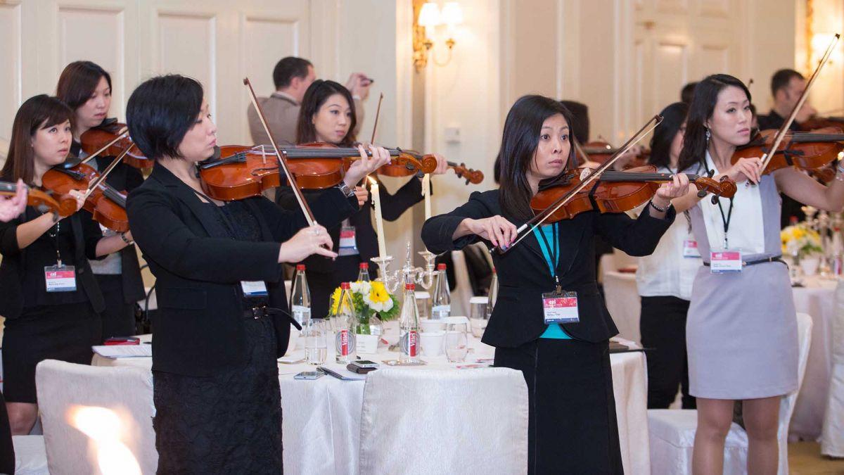 team performing as an orchestra musical team building challenge music