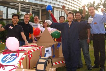 team celebrate completion of formula one car