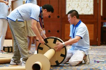 team collaborate to complete flat out rickshaw rally team building fun activity