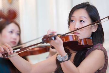 women playing violin crescendo musical team building activity