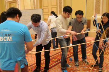 employees collaborate to complete innovative team building programme
