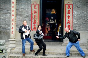 team striking a funny pose outside a building during travel show outdoor team building activity