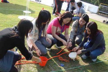 employees collaborate to complete breakthrough team building activity