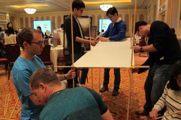 employees collaborate to complete bridging the divide creative team building activity