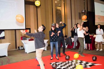 team having fun with colourful balloons win it in a minute competitive team building game