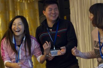 three people laughing having fun one voice team building activity