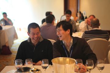 two men sitting at a cafe table during team building event