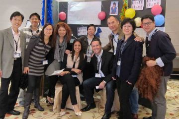 team posing with their arms up out of the box team building activity