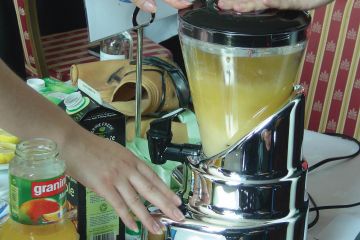 Hand on a blender start button mixing juices in the business game Creative Juices by Catalyst Global