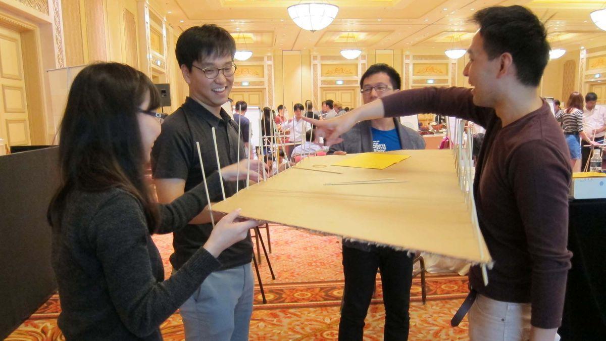 team collaborate to complete bridging the divide team building programme resized