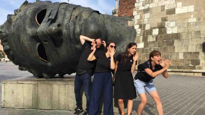 posing in front of a statue
