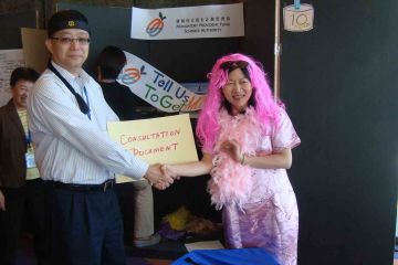 team posing with their arms up out of the box team building activity