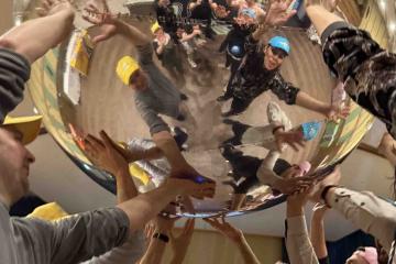 Teams lift a gigantic mirror ball