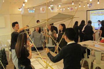 employees collaborate to complete bridging the divide creative team building activity