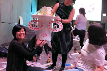 team collaborate to construct a puppet creative team building activity