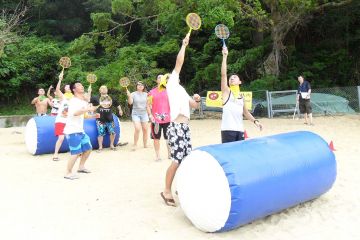 employees collaborate to complete breakthrough team building activity on the beach