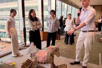 Colleagues engaged in lively racing activity with cheering spectators
