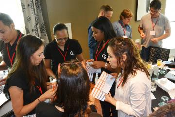 People in a conference smiling and chatting with each other in Catalyst team building activity Knowing Me Knowing You.