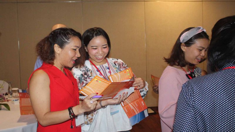 two women happily collaborate in work style networking business game