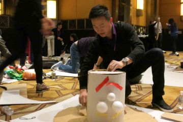 team collaborate to construct a puppet creative team building activity