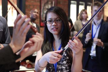 woman holding a bow for playing violin crescendo musical team building activity