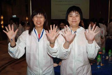 two women show their hands with paint on creative team building activity