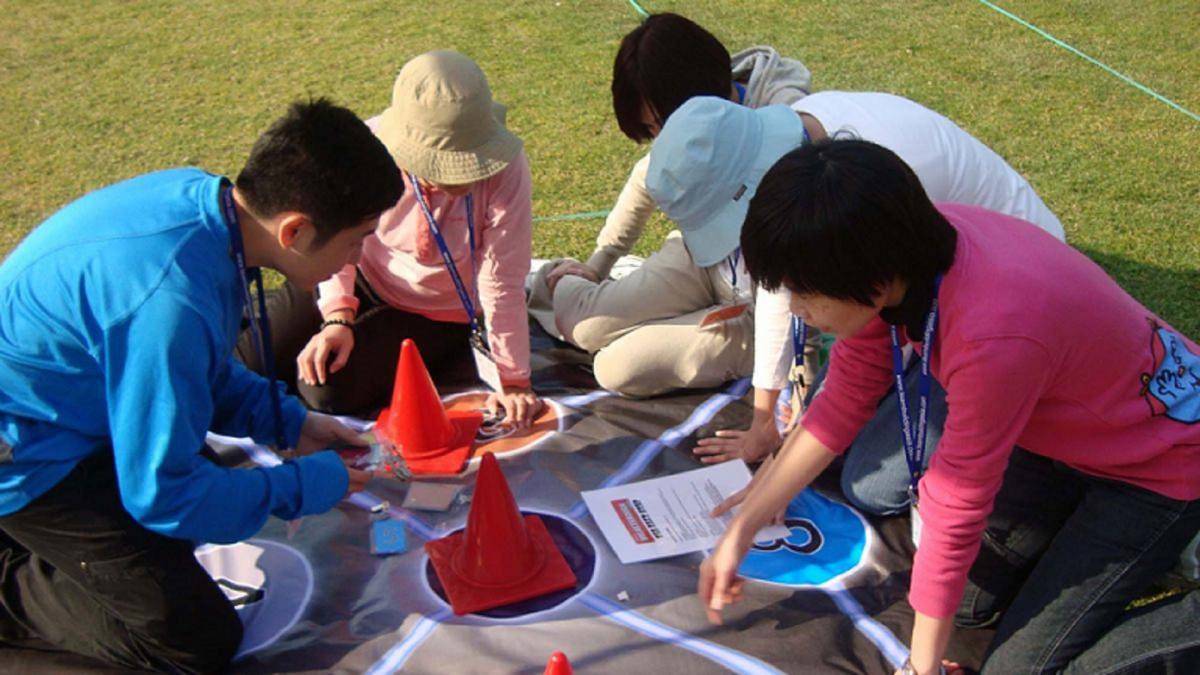 teamwork to complete outdoor team building challenge