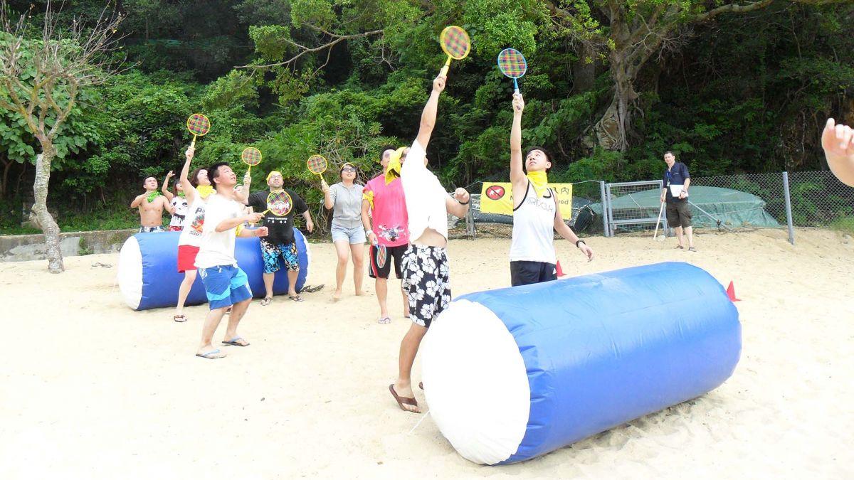 	team in action to complete team building challenges beach