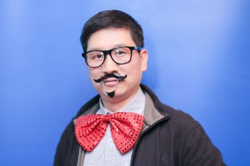 man wearing funny mustache and big bow tie unny wig and a big bow tie in the picture fun team building activity