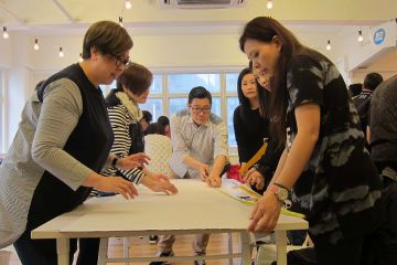 employees collaborate to complete bridging the divide creative team building activity